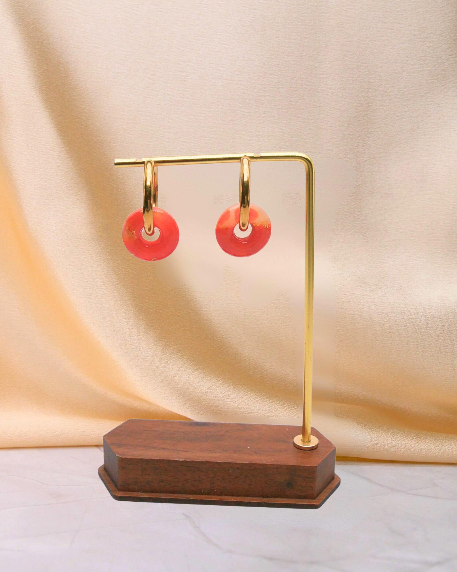 Créoles anneaux orange Maison Oneiri, boucles d’oreilles artisanales dorées avec anneaux marbrés orange et feuille d’or, fabriquées à la main en France.