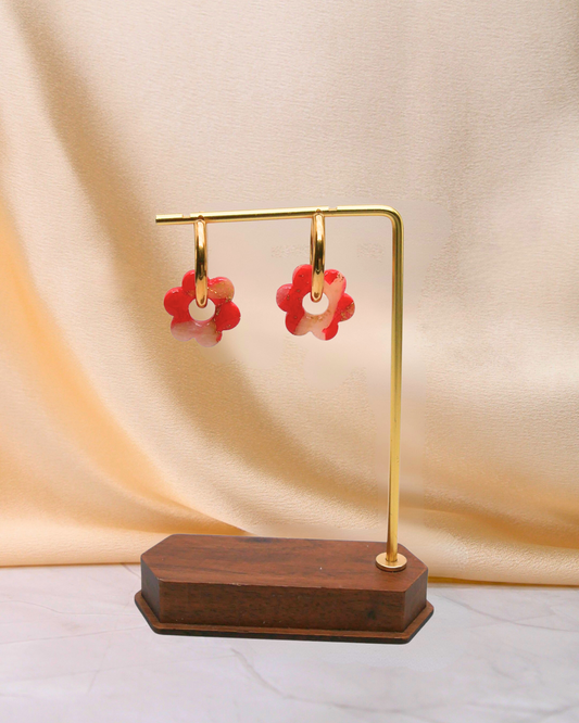 Créoles fleurs rouges artisanales Maison Oneiri, boucles d’oreilles dorées avec fleurs marbrées rouges et feuille d’or, faites main en France.